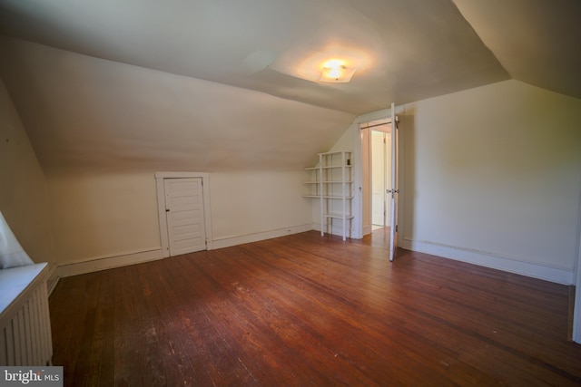 additional living space with baseboards, vaulted ceiling, and hardwood / wood-style floors