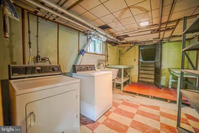 laundry room with laundry area, washer and clothes dryer, a sink, and tile patterned floors