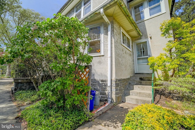 view of property exterior featuring stucco siding and stone siding