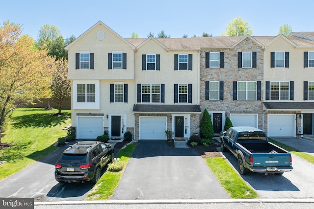 multi unit property featuring stucco siding, driveway, stone siding, and a garage