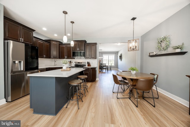 kitchen featuring light wood-type flooring, baseboards, dark brown cabinetry, and stainless steel appliances