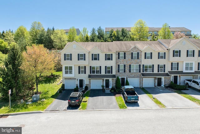 multi unit property featuring an attached garage, stucco siding, and driveway