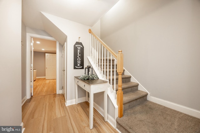 stairway with recessed lighting, baseboards, and wood finished floors