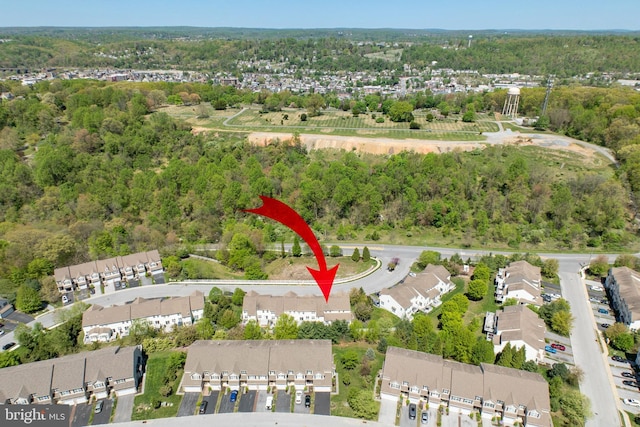 drone / aerial view with a wooded view and a residential view