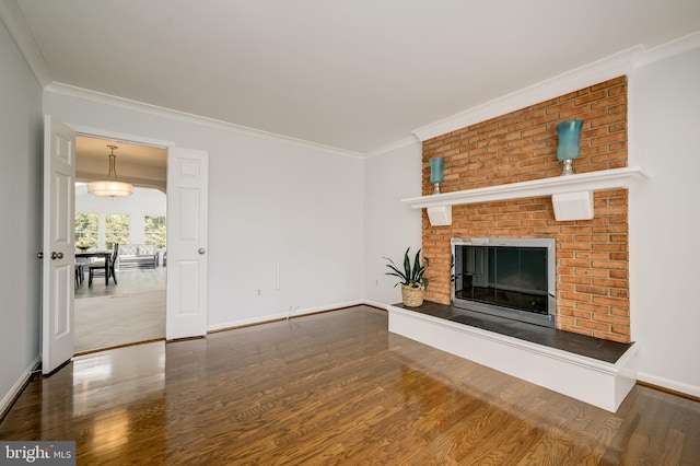 unfurnished living room with crown molding, baseboards, a fireplace, and wood finished floors