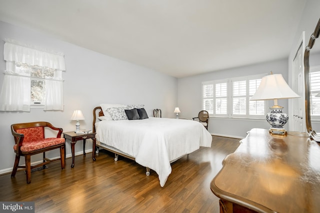 bedroom featuring baseboards and dark wood finished floors