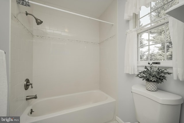 bathroom with bathing tub / shower combination and toilet