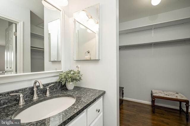 bathroom with vanity, baseboards, and wood finished floors