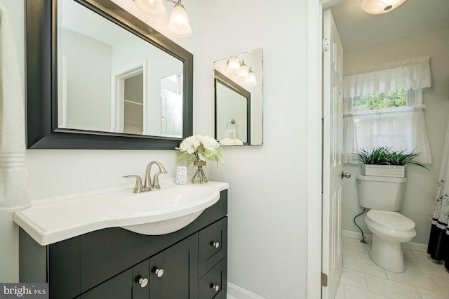bathroom featuring toilet, baseboards, marble finish floor, and vanity