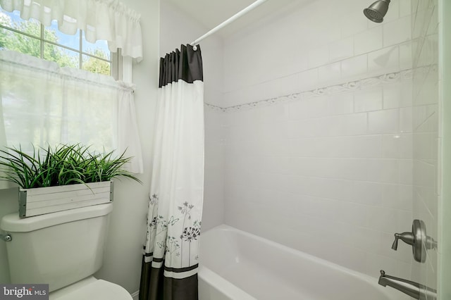 bathroom featuring shower / bath combo with shower curtain and toilet
