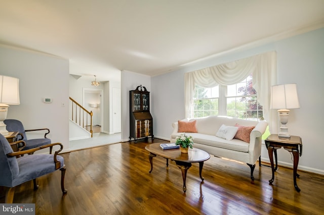 living room with baseboards, wood finished floors, and stairway