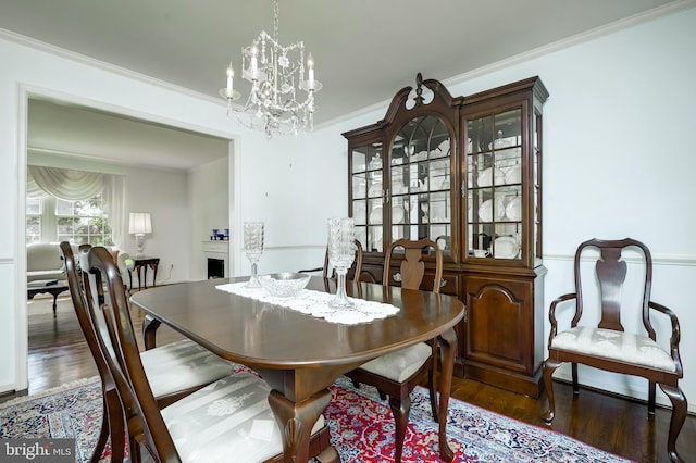 dining room featuring crown molding, a notable chandelier, and wood finished floors
