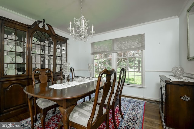 dining room with crown molding, baseboards, wood finished floors, and a chandelier