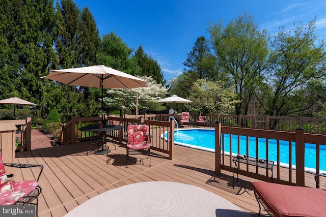 view of pool featuring outdoor dining space, a wooden deck, and a fenced in pool