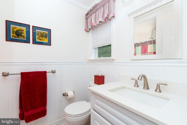full bath with toilet, curtained shower, a wainscoted wall, and vanity