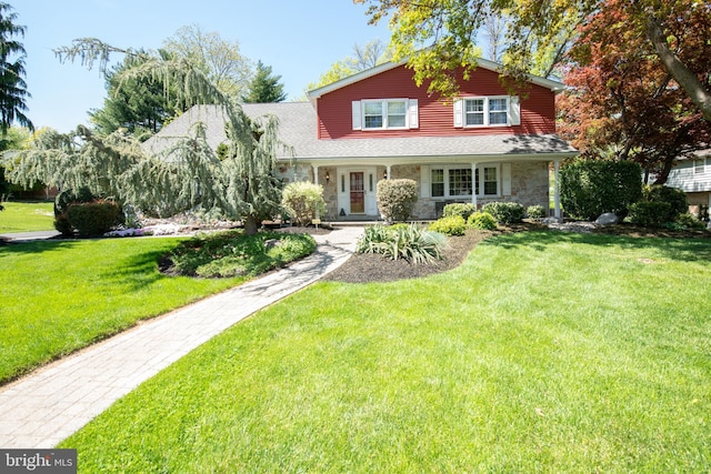 view of front of home with a front yard and stone siding