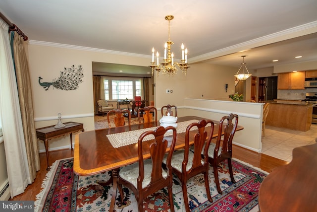 dining area with crown molding, baseboard heating, baseboards, a chandelier, and light wood-style flooring
