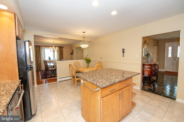kitchen featuring a kitchen island, appliances with stainless steel finishes, light stone countertops, a baseboard heating unit, and recessed lighting