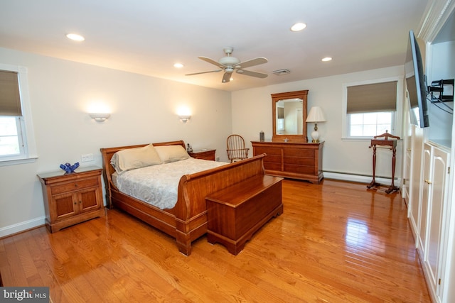 bedroom featuring light wood-style floors, recessed lighting, and a baseboard heating unit