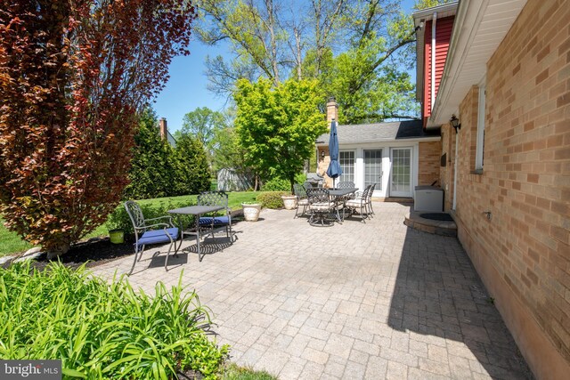 view of patio with an outbuilding, outdoor dining space, and a shed