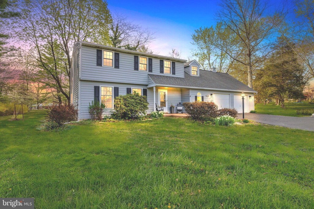 view of front facade with driveway, a front yard, and an attached garage
