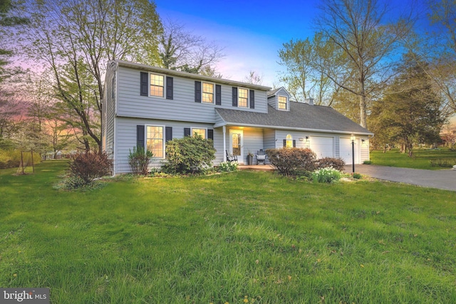 view of front facade with driveway, a front yard, and an attached garage