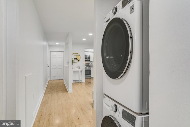washroom with laundry area, stacked washer and clothes dryer, baseboards, recessed lighting, and light wood finished floors
