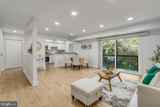 living room with light wood-type flooring, recessed lighting, and baseboards
