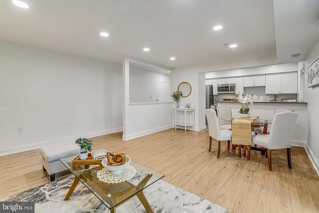 living area featuring recessed lighting, baseboards, visible vents, and light wood finished floors