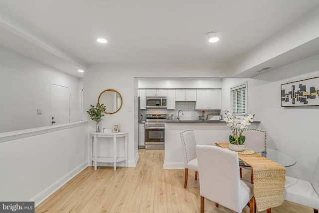 dining area featuring recessed lighting, light wood-style flooring, and baseboards