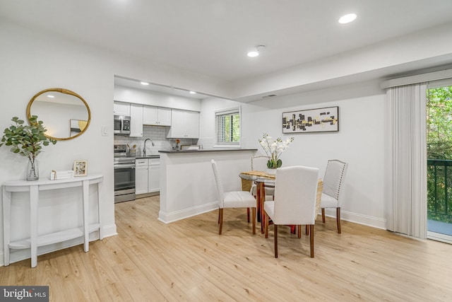 dining room featuring baseboards, recessed lighting, and light wood-style flooring