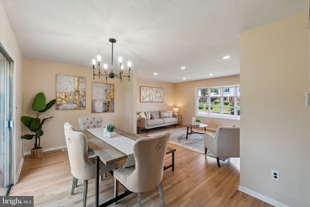 dining room featuring an inviting chandelier, light wood-style floors, baseboards, and recessed lighting