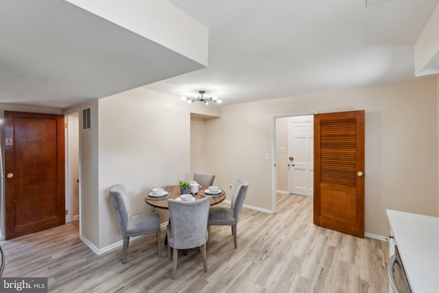 dining area featuring light wood-style flooring, baseboards, and visible vents