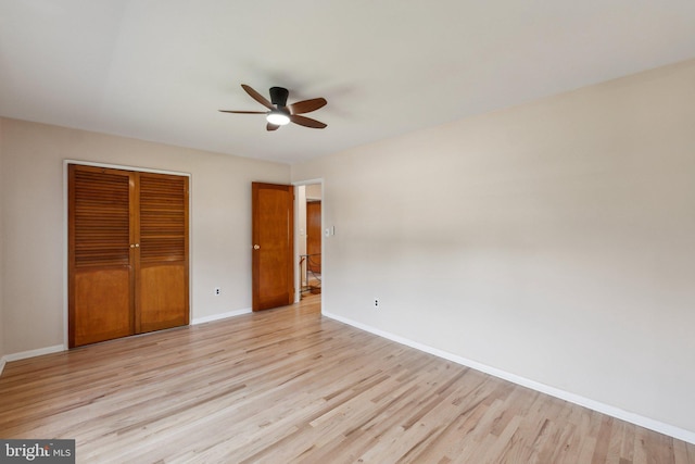 unfurnished bedroom featuring a closet, light wood-type flooring, baseboards, and ceiling fan
