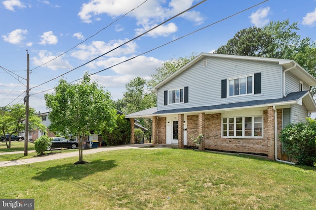 view of front of home featuring brick siding, driveway, and a front yard