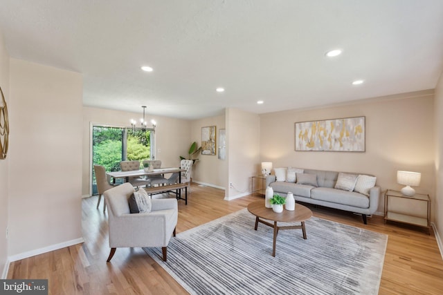living area with recessed lighting, light wood-type flooring, baseboards, and a notable chandelier