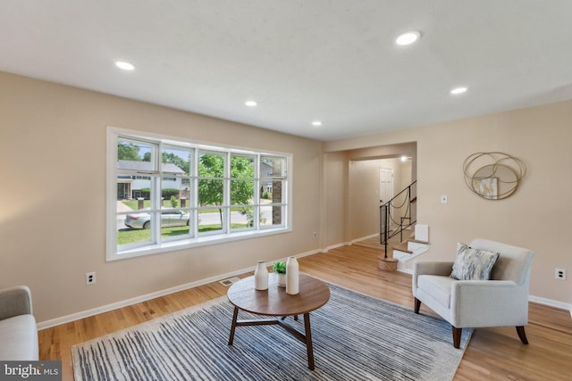 living room featuring wood finished floors, stairs, visible vents, baseboards, and recessed lighting