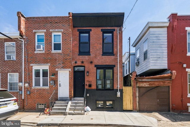 view of property featuring brick siding, entry steps, and an attached garage
