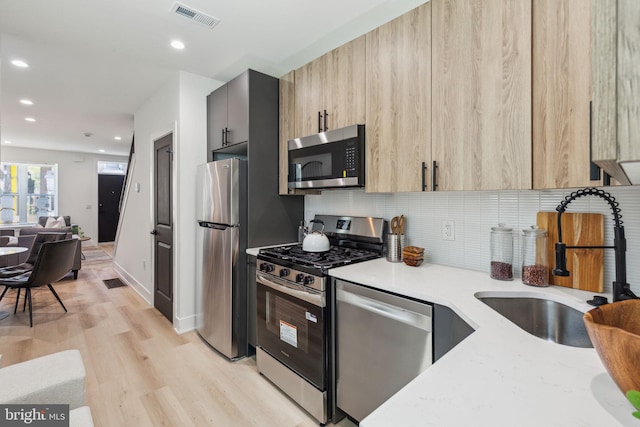 kitchen with modern cabinets, visible vents, stainless steel appliances, and a sink