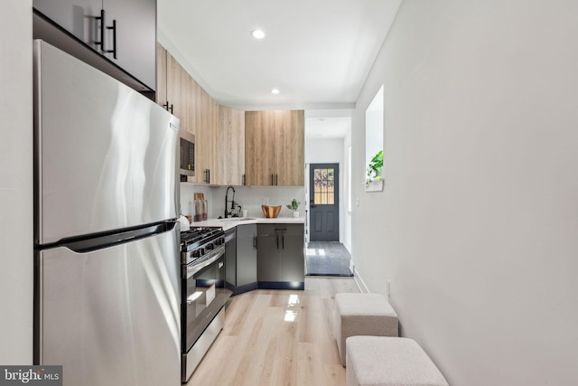 kitchen with recessed lighting, light wood finished floors, stainless steel appliances, light countertops, and tasteful backsplash