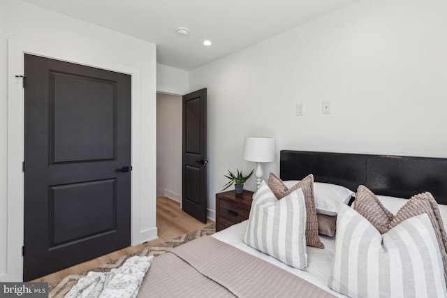 bedroom with baseboards, wood finished floors, and recessed lighting