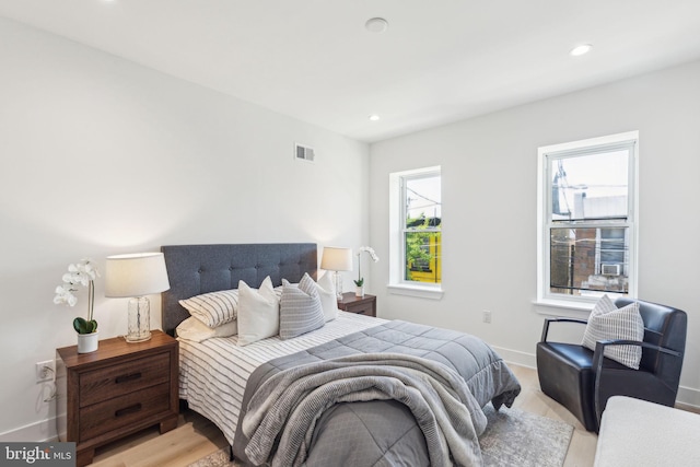 bedroom featuring baseboards, light wood-style flooring, visible vents, and recessed lighting