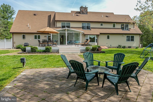 back of house featuring a patio, a chimney, a shingled roof, and an outdoor fire pit