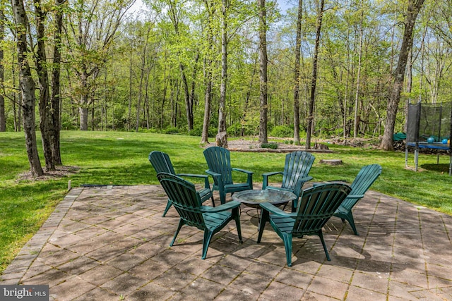 view of patio / terrace with a trampoline and a fire pit