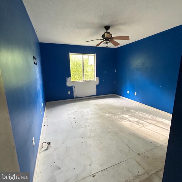 spare room featuring a ceiling fan and a textured ceiling