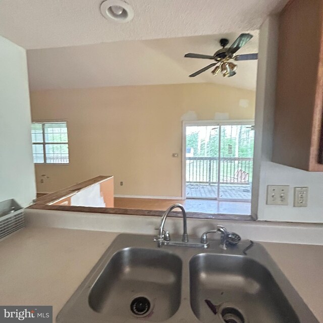 kitchen with ceiling fan, lofted ceiling, and a sink