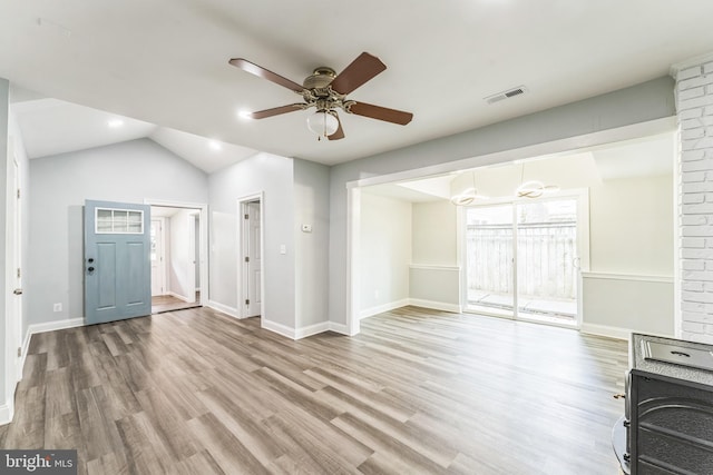 unfurnished living room featuring lofted ceiling, wood finished floors, visible vents, a ceiling fan, and baseboards
