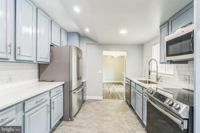 kitchen with a sink, recessed lighting, backsplash, light countertops, and appliances with stainless steel finishes