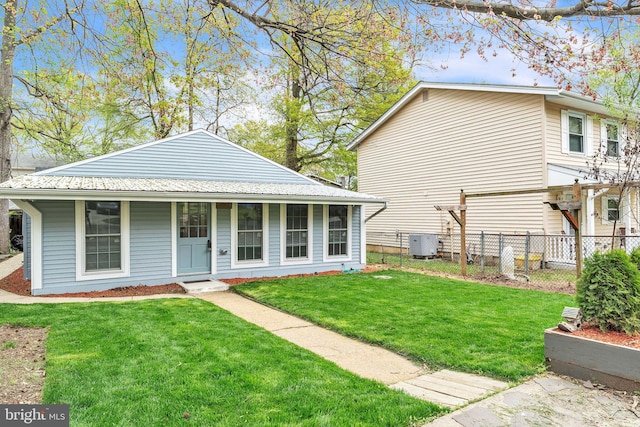 view of front of house featuring central air condition unit, fence, a porch, and a front yard
