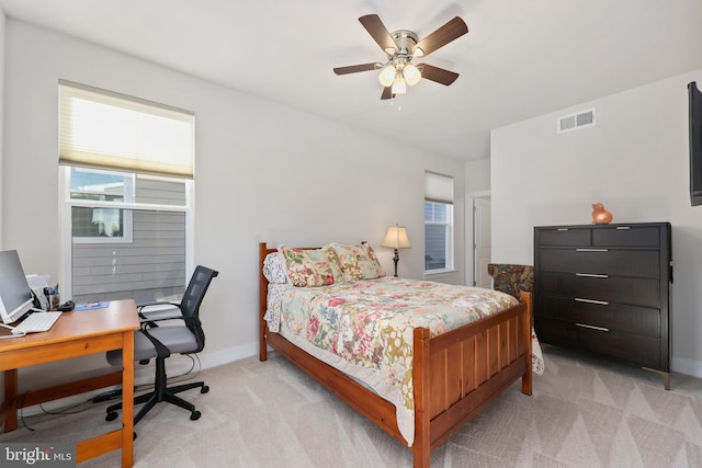 bedroom featuring visible vents, light carpet, baseboards, and multiple windows
